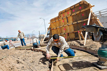 Clayton Edaakie and other City of Gallup Construction and Maintenance workers take measurements for the concrete at the new Chihuahuita neighborhood memorial at the corner of Aztec Avenue and Eighth Street on Wednesday. The memorial will feature a small walkway, a plaque, a mock mine shaft and landscaping. © 2011 Gallup Independent / Cable Hoover